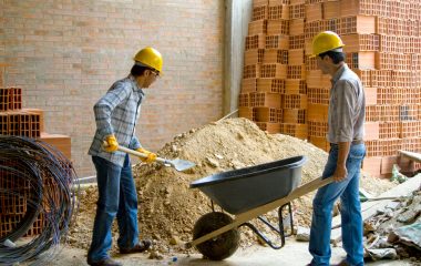 Happyconstructionworkerswearinghelmetsandworking-teamworkconcepts